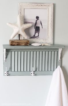 a towel rack with two starfish on it and a framed photo in the background