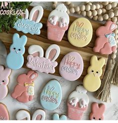 decorated cookies with bunny, rabbit and easter eggs on a tray next to other decorations