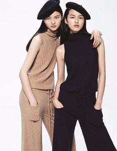 two young women standing next to each other with hats on their heads and one wearing a black hat