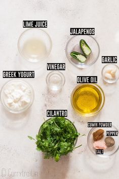 the ingredients for this recipe are shown in small bowls on a white counter top, including avocado, cilantro, lime, jalapenos, and sour cream cheese