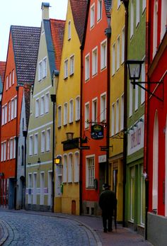 a cobblestone street lined with brightly colored buildings