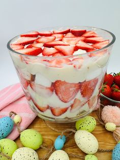 a bowl of strawberries and eggs on a table next to some other fruit items