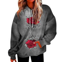 a woman wearing a grey hoodie with red roses on it