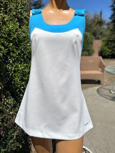 Here is a vintage 1970s White Polyester tennis dress .Made by Head .Following are the measurements.Bust 32", waist 30",hips 38",length measured from top of shoulder to bottom 28".Zips up the back. Blue neckline and straps.In very nice vintage condition.Please take note tennis dresses were very short . Barely covering the bum. Not like a regular dress.Please e mail me if you live overseas for mailing cost before purchasing.Shipping price quoted is for USA only 1970s Blue Fitted Dress, Blue A-line Mod Dress, 1970s Fitted White Dress, Fitted Mod Dresses For Daywear, Fitted White 1970s Dress, Mod Style Fitted Dresses For Daywear, White Fitted 1970s Style Dress, White 1970s Fitted Dress, Tennis Dresses