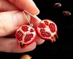 "Introducing our Pomegranate Jewelry Collection, inspired by the mythical tale of Persephone. Adorn your ears with our Persephone Earrings, featuring sterling silver and miniature fruit charms. These cute dangle earrings are handmade, showcasing the beauty of Armenian craftsmanship and Jewish jewelry traditions. Symbolizing abundance and fertility, pomegranate seeds make these earrings meaningful Judaica gifts. Explore the enchanting world of Greek mythology with our unique collection, blending Interesting Earrings Unique, Ceramic Fruit Earrings, Fruit Design Drop Earrings As Gift, Fruit Design Drop Earrings For Gift, Elegant Dangle Jewelry With Fruit Design, Elegant Fruit Design Dangle Jewelry, Silver Jewelry With Fruit Design For Gifts, Persephone Earrings, Spirit Protection