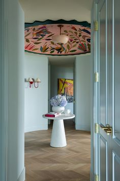 a white table with vases on top of it in a room next to a doorway