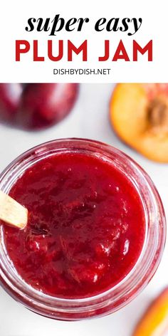 a jar filled with plum jam sitting on top of a table