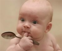 a baby is holding a spoon in it's mouth