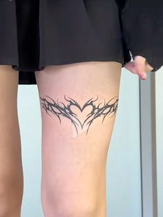 a woman's leg with tattoos on it and a cross in the middle of her thigh