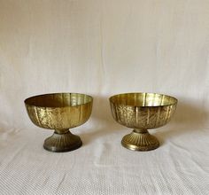 two brass bowls sitting on top of each other