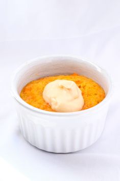 a white bowl filled with food sitting on top of a white table next to a fork