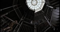 the inside of a spiral stair case with a skylight in the center and metal railings on both sides