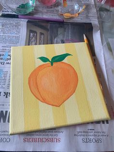 an orange painted on top of a piece of paper