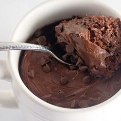 a spoon in a mug filled with chocolate ice cream