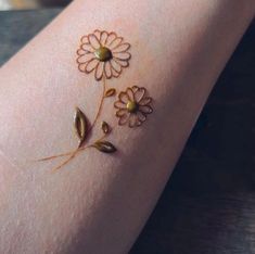 a woman's arm with flowers painted on it