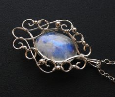 This stunningly elegant pendant necklace is handcrafted from sterling silver and a gorgeous rainbow moonstone cabochon, with lovely flashes of blue color. Pendant comes with an Italian made .925 sterling silver chain with lobster clasp (see photos) in your choice of length. Generously sized bail allows you to swap out different chain styles, if desired. One of a kind pendant measures approximately 2 inches long by 1.25 inches wide, and will come beautifully gift boxed, as shown in last photo. Sh Elegant Silver Labradorite Necklaces, Elegant Oval Labradorite Pendant Jewelry, Elegant Silver Labradorite Necklace, Elegant Oval Labradorite Jewelry, Handmade Moonstone Jewelry In White Gold, Handmade White Gold Moonstone Jewelry, Elegant Silver Labradorite Jewelry, Elegant Hand Forged Moonstone Jewelry, Wire Jewelery