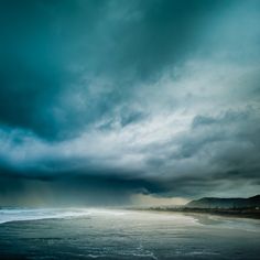 the sky is dark and cloudy over the ocean