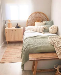 a bed with pillows and blankets on it in a room next to a dresser, rugs and other items