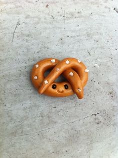 a pretzel with white dots on it laying on the ground