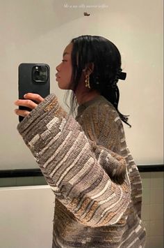 a woman taking a selfie in front of a mirror with her cell phone up to her ear