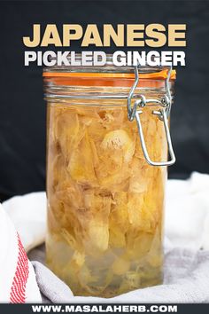 a jar filled with pickled ginger sitting on top of a white towel next to a black background