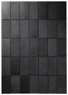 a black tile wall with diagonal lines on it