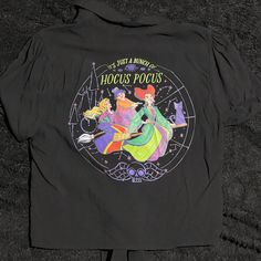 the back of a black shirt with an image of two princesses and one is wearing a hat