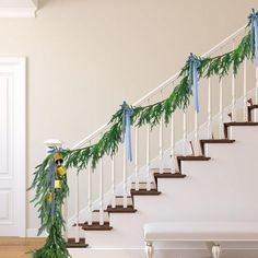 a staircase decorated with garland and blue bows