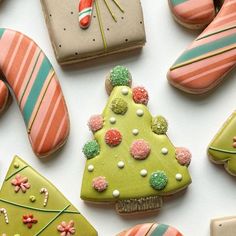 decorated cookies are arranged in the shape of a christmas tree and candy canes on a white surface