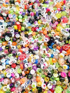 many different colored and shaped beads are scattered together on the ground, with numbers written in them