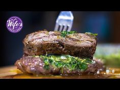 a piece of steak on top of a wooden cutting board with a fork in it