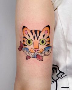 a cat and fish tattoo on the arm