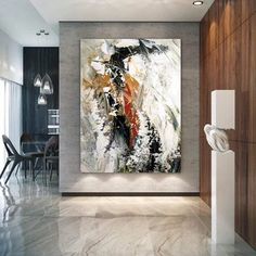 an abstract painting hangs on the wall in a modern living room with marble floors and white walls