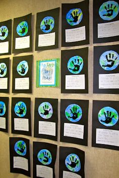 a wall with many handprints on it and some papers attached to the wall