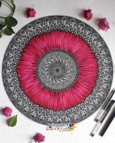 a drawing of a pink flower on top of a white table with pens and markers