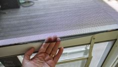 a person's hand reaching for something on the window sill