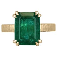 This 4.45-carat natural emerald cut emerald from Zambia is a showstopper. The emerald is cut in a classic emerald cut style, which shows off the stone's clarity and depth of color. The emerald is set in a unique four-double claw prong setting, which adds a modern twist to the classic style. The band of the ring is finished in matte hammered gold in 18K, which gives it a rustic and organic feel. The gold finish provides a beautiful contrast to the deep green of the emerald and adds a touch of war Solitaire Setting, Claw Prong, Hammered Gold, Yellow Gold Setting, Set Ring, Zambia, Natural Emerald, Deep Green, Solitaire Ring