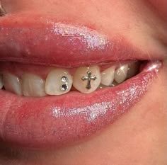 a woman's mouth with white teeth and cross on it