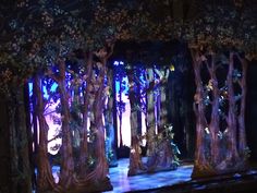 a stage set with trees and flowers on it