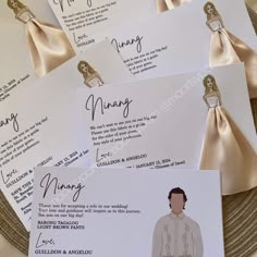 the wedding program cards have been folded on top of each other and are decorated with gold ribbon