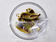 some green peppers wrapped in plastic on a plate