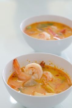 two white bowls filled with soup and shrimp