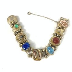 Victorian revival watch chain bracelet, made from reproduction watch and bracelet slides.  The bracelet is unmarked, but it is gold tone with high quality glass gems. It includes lapis style, Peking jade glass, Hubbell glass, and two gorgeous Italian Murano style and aventurine gems, plus a roaring lion and a bow. It's gorgeous and impressive, and this particular size and quality is VERY hard to find.  From the 1950's. I believe. Some wear, as expected, but in beautiful shape. Stones are not cho Antique Jeweled Jewelry, Antique Multi-stone Round Jewelry, Antique Multi-stone Bracelet As Gift, Antique Multi-stone Bracelets As Gift, Heirloom Gold Multi-stone Bracelets, Heirloom Gold Bracelets With Multi-stone, Heirloom Round Jeweled Jewelry, Antique Adjustable Jeweled Jewelry, Unique Collectible Jeweled Jewelry