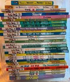 a stack of children's books sitting on top of a plastic container filled with them