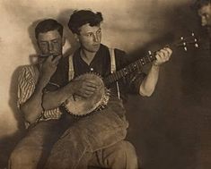 two men are playing musical instruments in an old photo