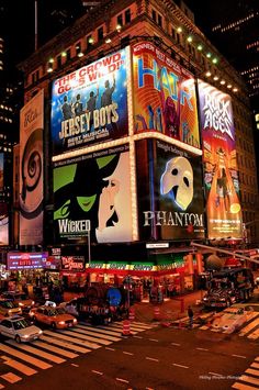 the times square in new york city is lit up at night with many billboards