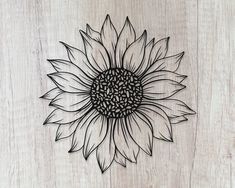 a metal sunflower sitting on top of a wooden table