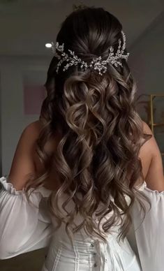 the back of a woman's head with long wavy hair wearing a tiara