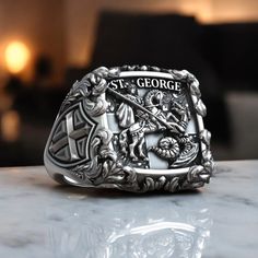 This Saint George the Victorious Knight Cross Signet Ring is crafted from 925 sterling silver, combining elegance and spirituality. The ring features a detailed depiction of Saint George, a revered Christian figure known for his bravery and faith. Perfect for those who want to showcase their devotion or wear a piece of Christian heritage. This ring makes a meaningful gift for birthdays, religious milestones, or simply as a statement of faith. Handcrafted to ensure the highest quality, this signe Cross Christian, Viking Ring, Masonic Ring, Retro Ring, Religious Symbols, Animal Rings, Saint George, Christian Jewelry, Handmade Rings