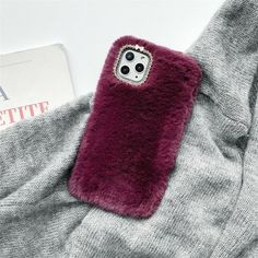 a cell phone case sitting on top of a gray sweater